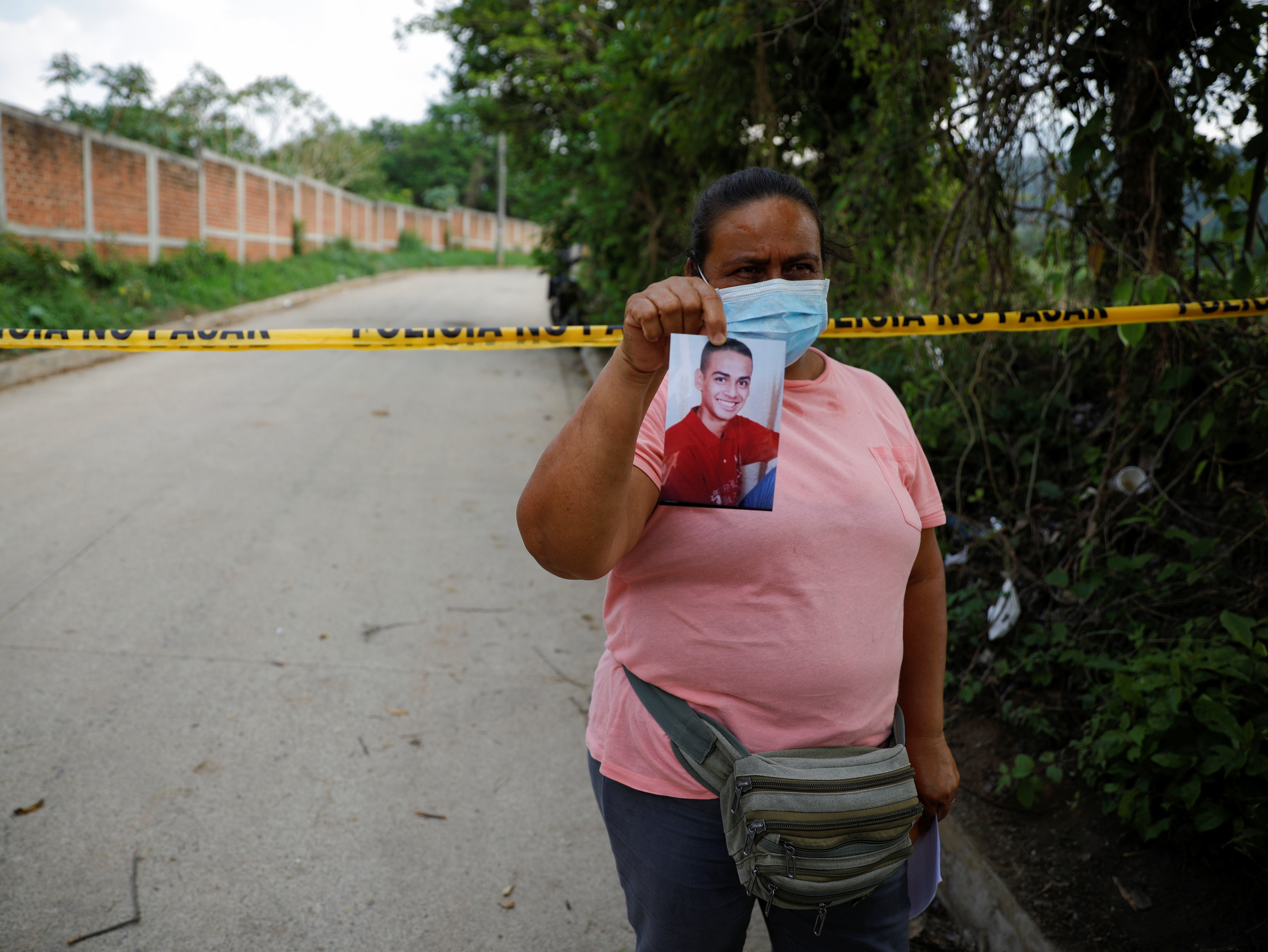 Marleny Barrientos shows a picture of her son who went missing six years ago and is believed to be at the site authorities are excavating.