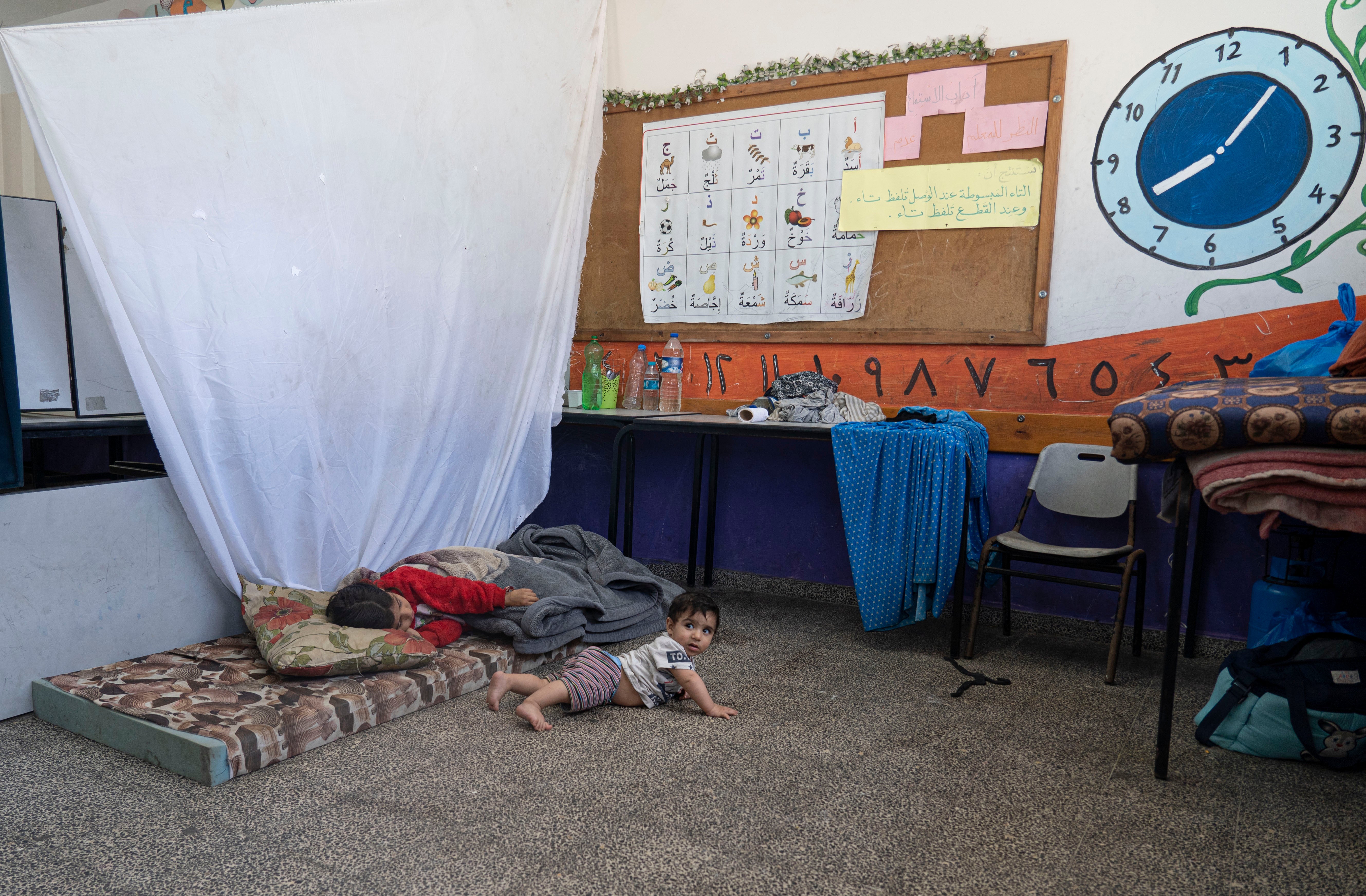 Children whose homes have been bombed rest in their makeshift bedroom in a UNRWA school