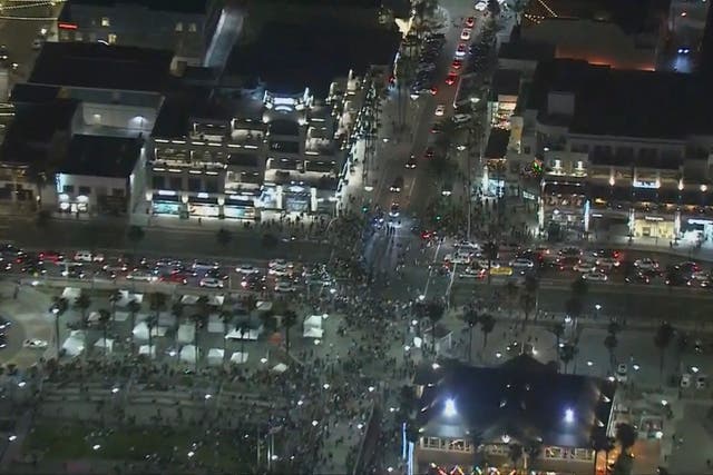 <p>This Saturday, May 22, 2021 aerial screenshot provided by FOX 11 KTTV shows people gathered at the Huntington Beach pier in Huntington Beach, Calif.</p>