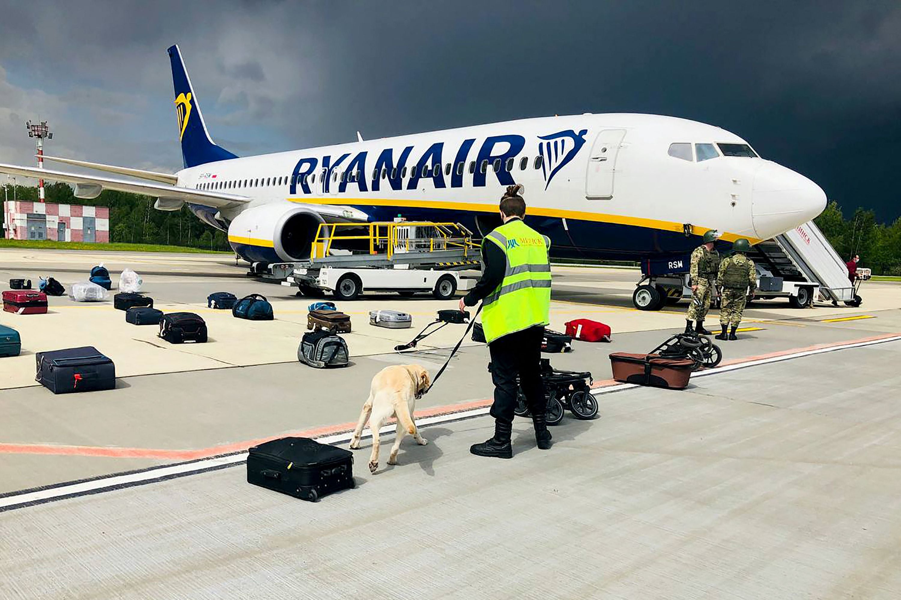 A Belarusian dog handler checks luggages off a Ryanair Boeing 737-8AS in Minsk