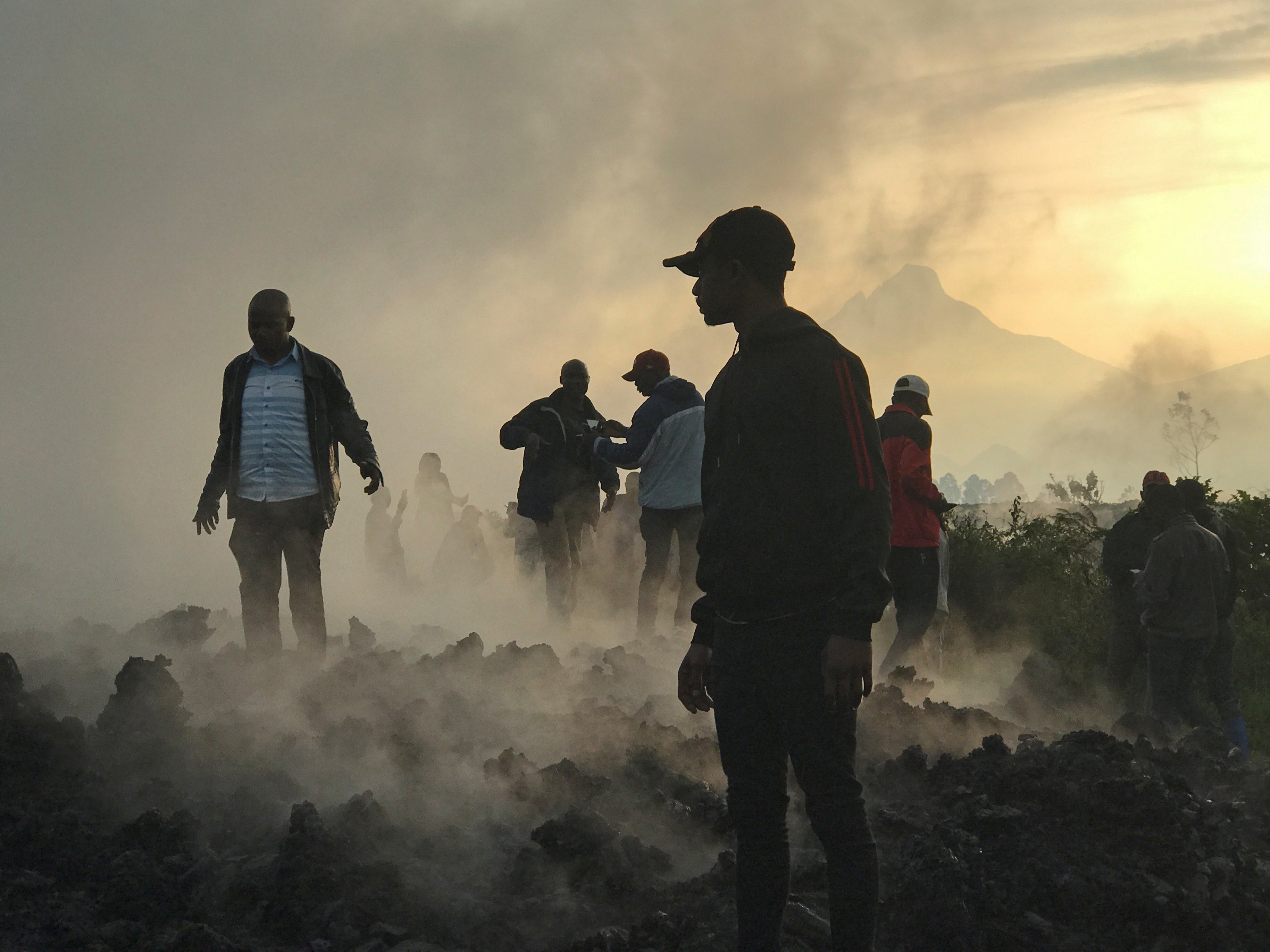 Residents pick through the smouldering rubble of their homes the morning after the eruption