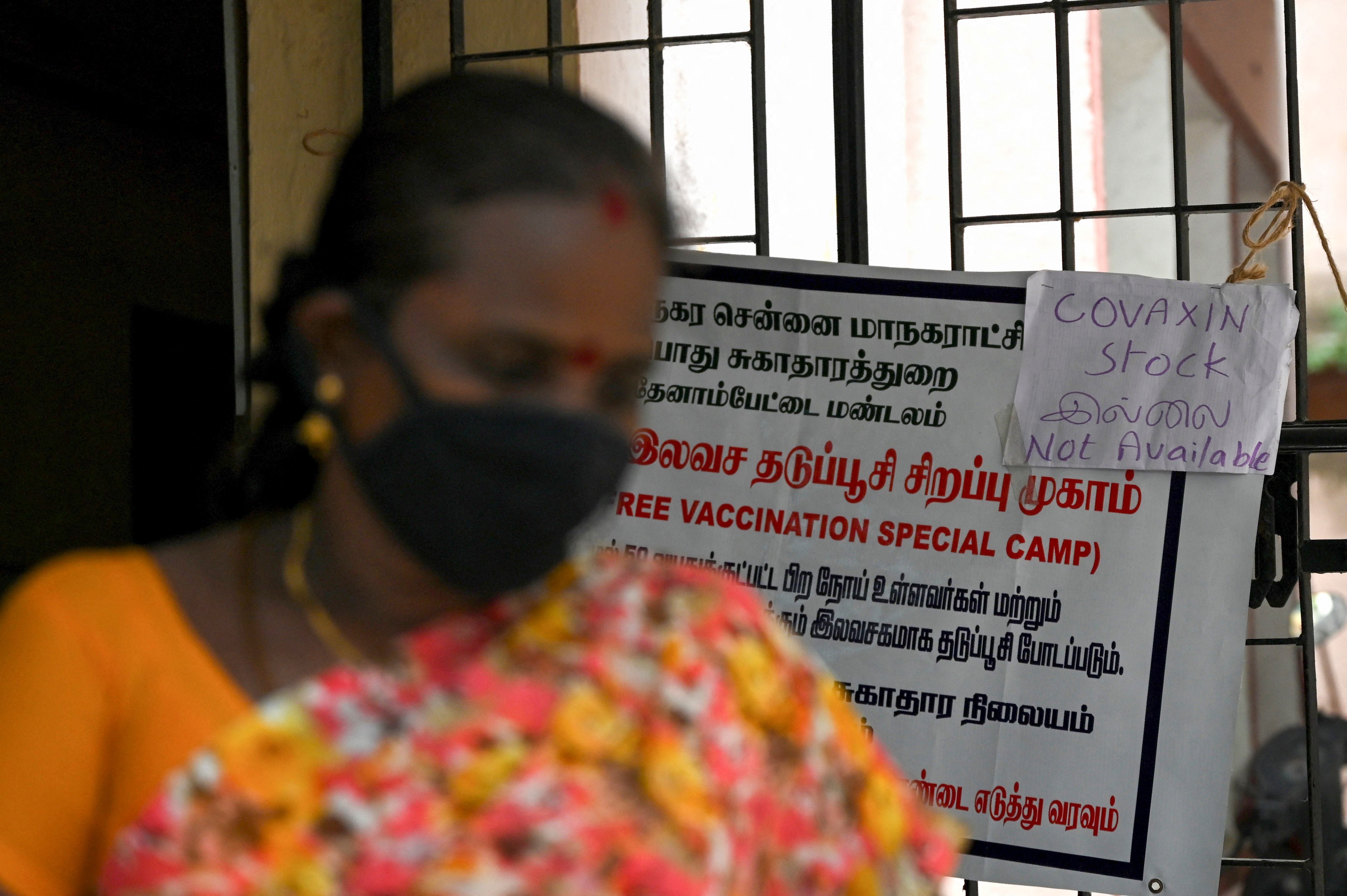 A woman walks past a notice announcing the unavailability of Covaxin Covid-19 coronavirus vaccine doses due to stock shortages at a primary health centre in Chennai on May 21, 2021. (Photo by Arun SANKAR / AFP) (Photo by ARUN SANKAR/AFP via Getty Images)