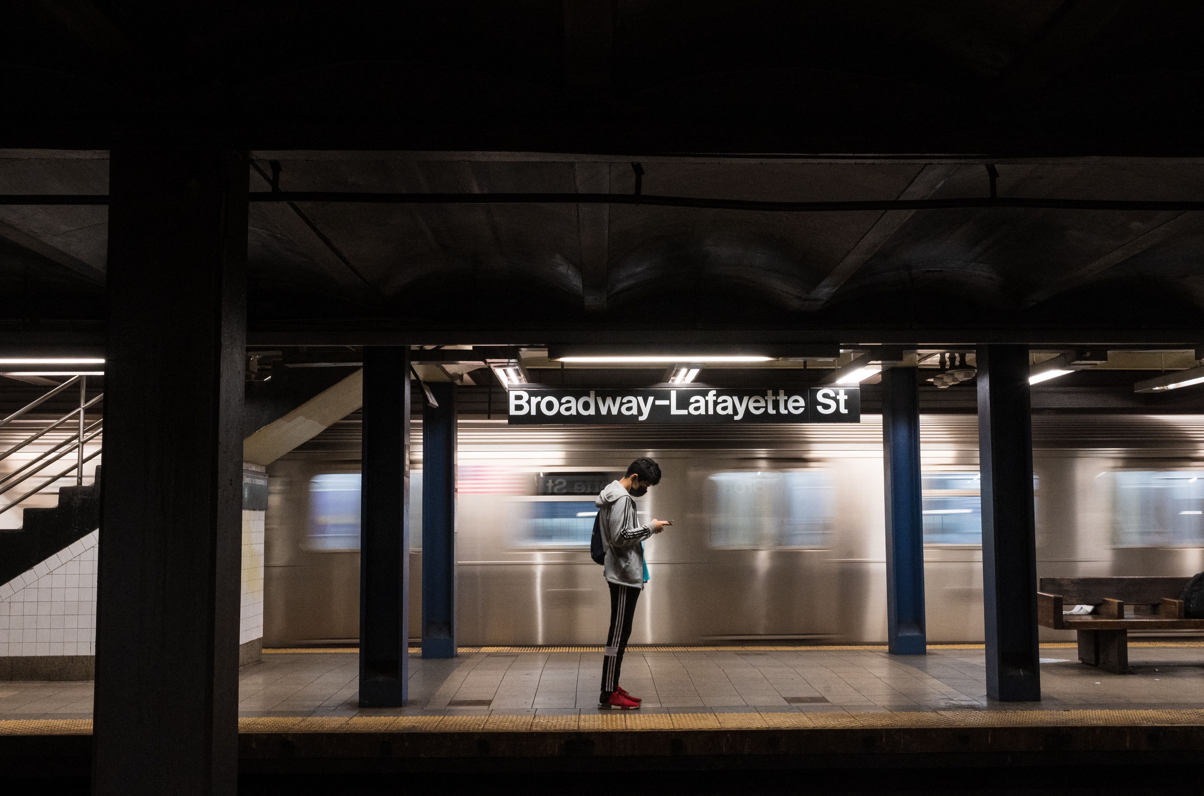<p>A person checks their phone on a subway platform as the subway returns to twenty-four hour service on May 17, 2021 in New York City.  Ridership dropped by 90% during 2020.</p>