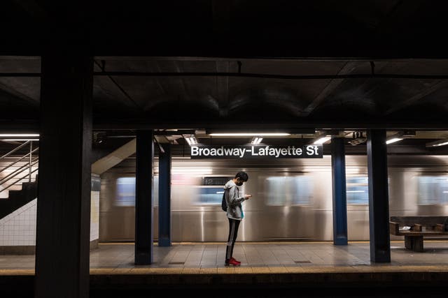 <p>A person checks their phone on a subway platform as the subway returns to twenty-four hour service on May 17, 2021 in New York City.  Ridership dropped by 90% during 2020.</p>