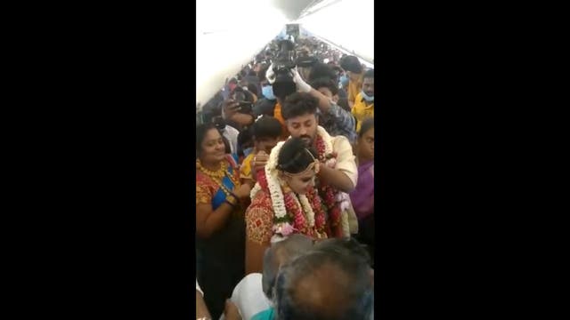<p>The visuals from a video of the mid-air wedding shows a plane packed with maskless guests as couple exchanged garlands</p>