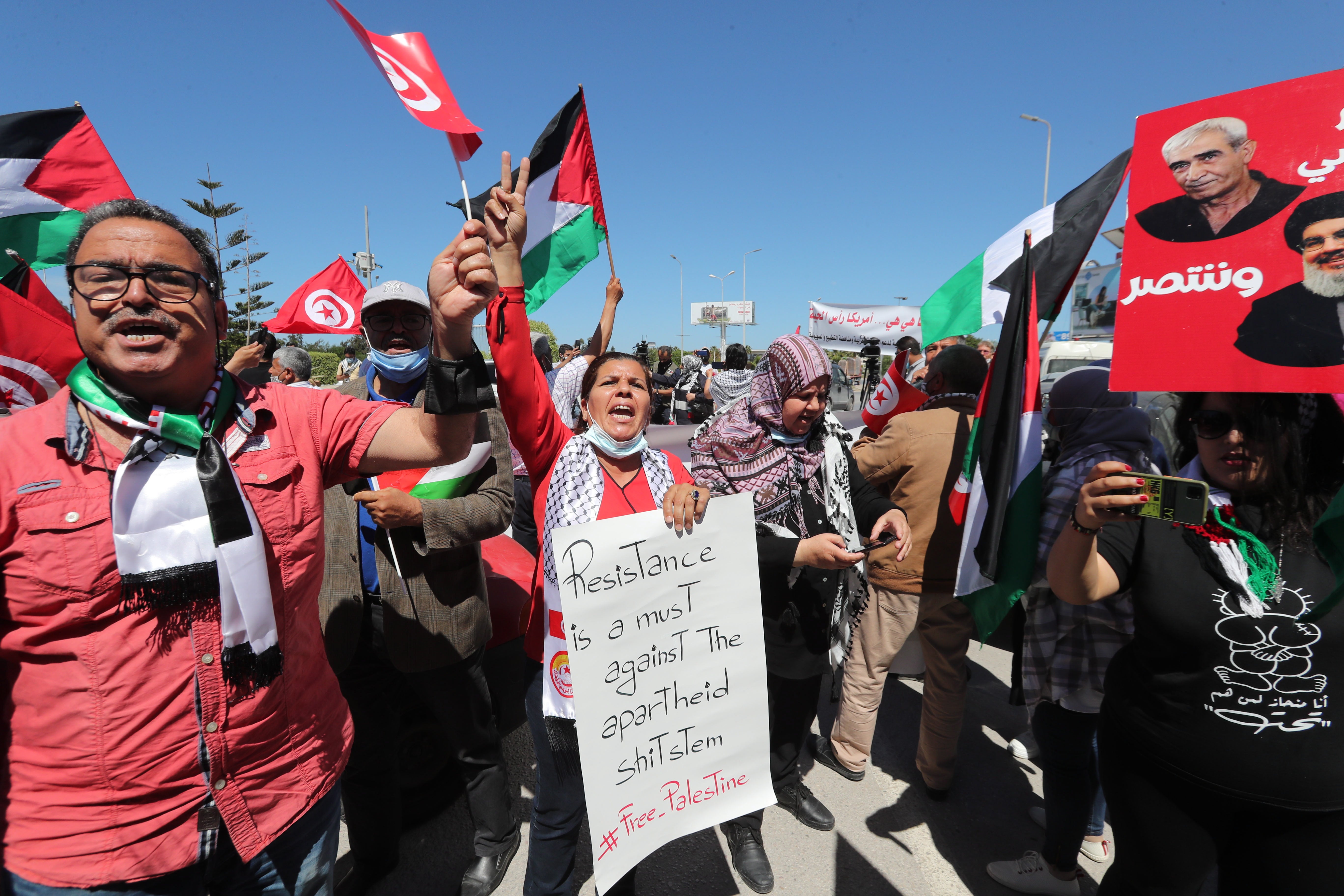 Tunisians wave Palestinian flags and chant anti-Israel slogans during a demonstration in solidarity with Palestine