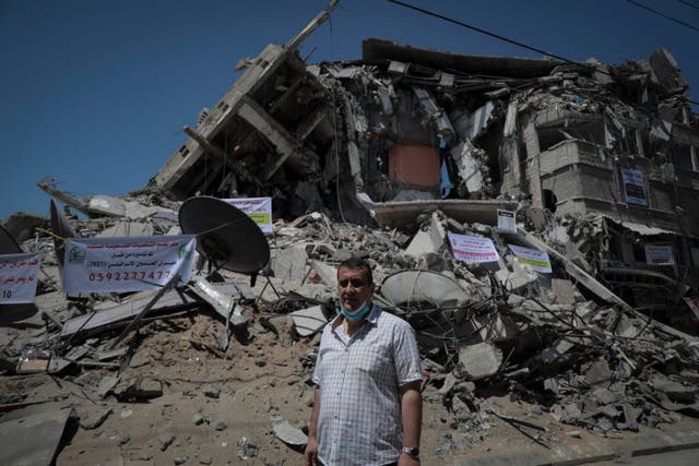 <p>Naji Dwaima, owner of Dwaima's for Watches, stands in front of the rubble of his shop in Gaza City</p>