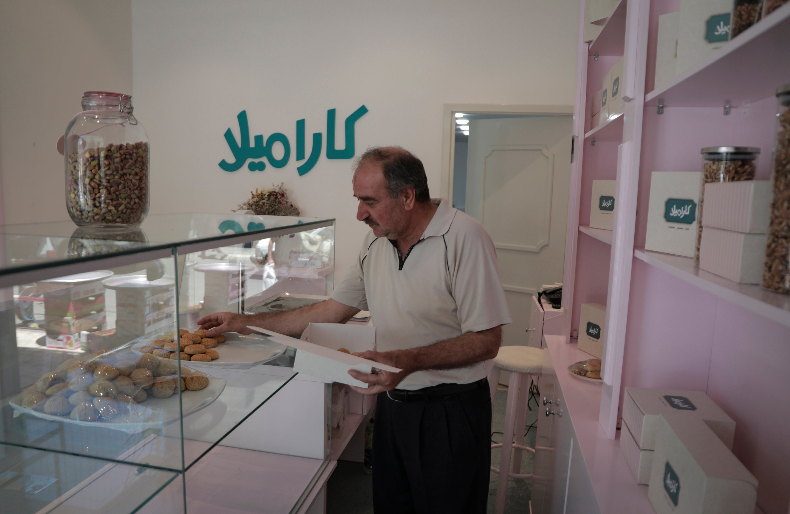 Sabir Nabahan packs cakes at his shop, Caramel, in Gaza City