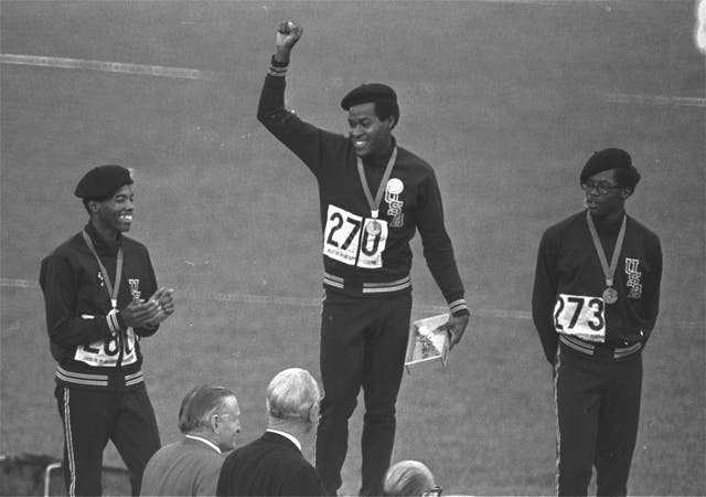 <p>Evans (centre) receives his gold medal for the 400m race in the 1968 Olympics</p>
