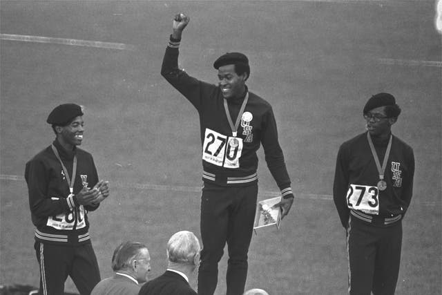 <p>Evans (centre) receives his gold medal for the 400m race in the 1968 Olympics</p>