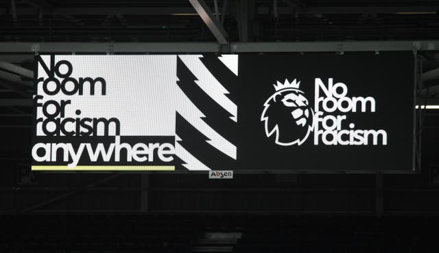 A big screen displaying a No Room For Racism video