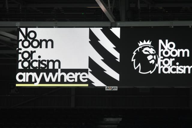 A big screen displaying a No Room For Racism video