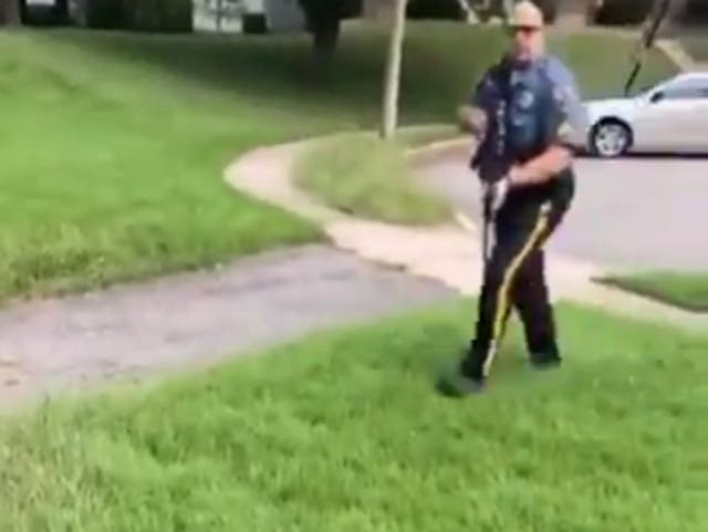 A police officer circles a pair of Black locksmiths who were contract to change the locks on a house, but had the police called on them