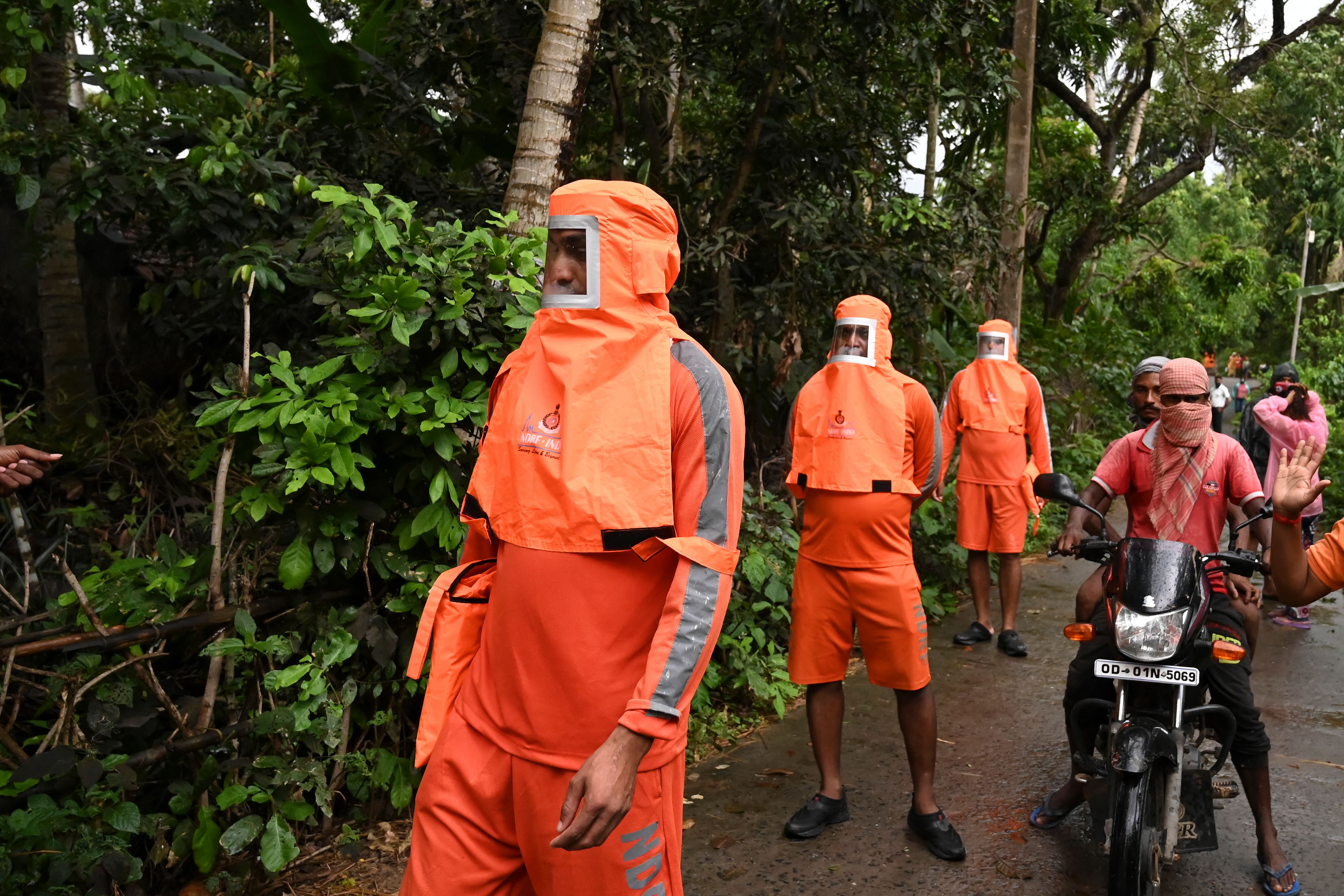 National Disaster Response Force personnel walk through a village and urge the villagers to evacuate