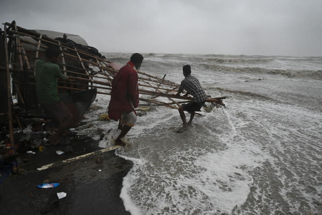 <p>Residents shift makeshift stalls as water reaches a road at a beachfront area in the state of Odisha’s Balasore district</p>