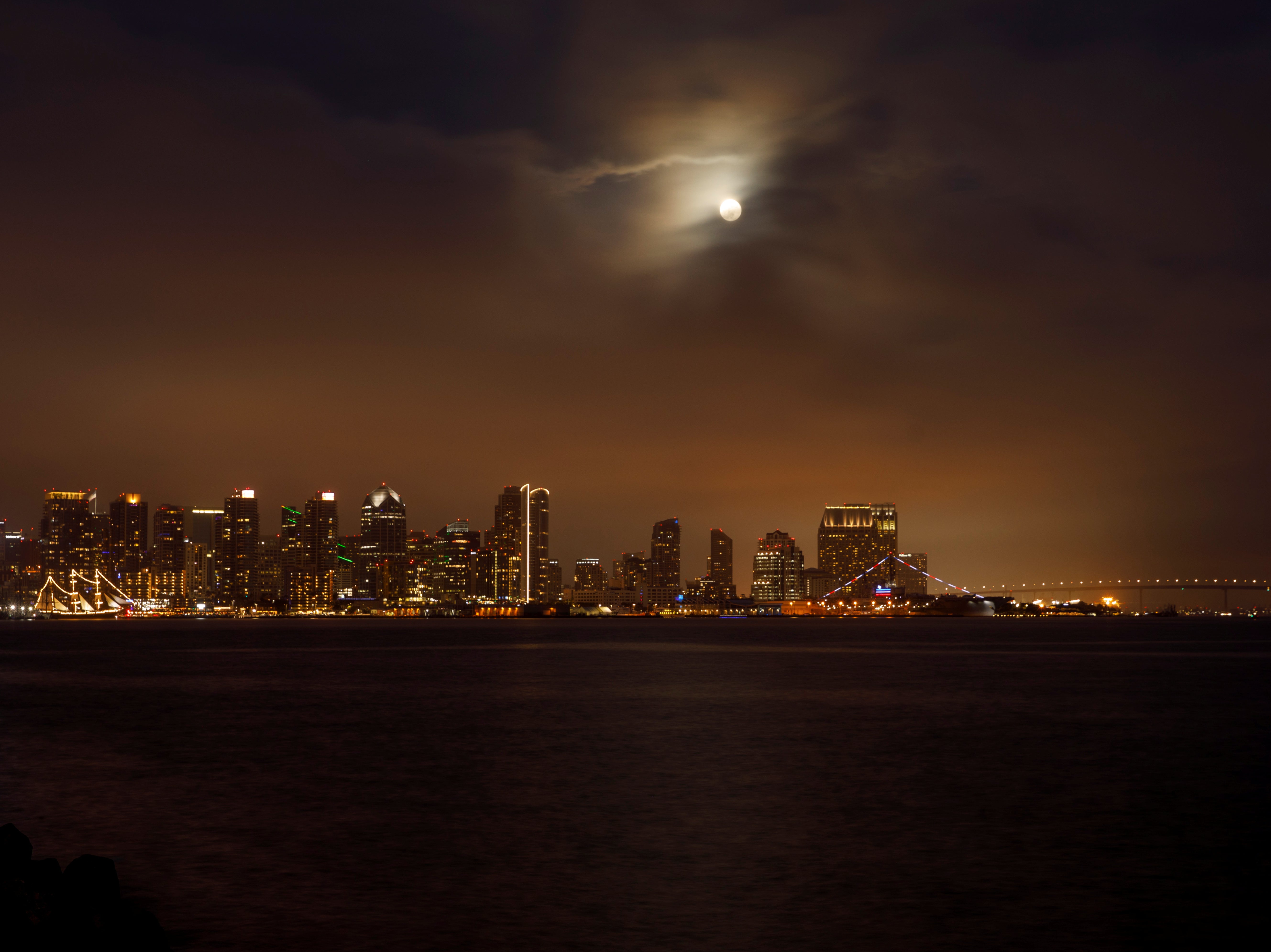 The moon peers through low clouds above the city of San Diego, California, on Tuesday 25 May 2021
