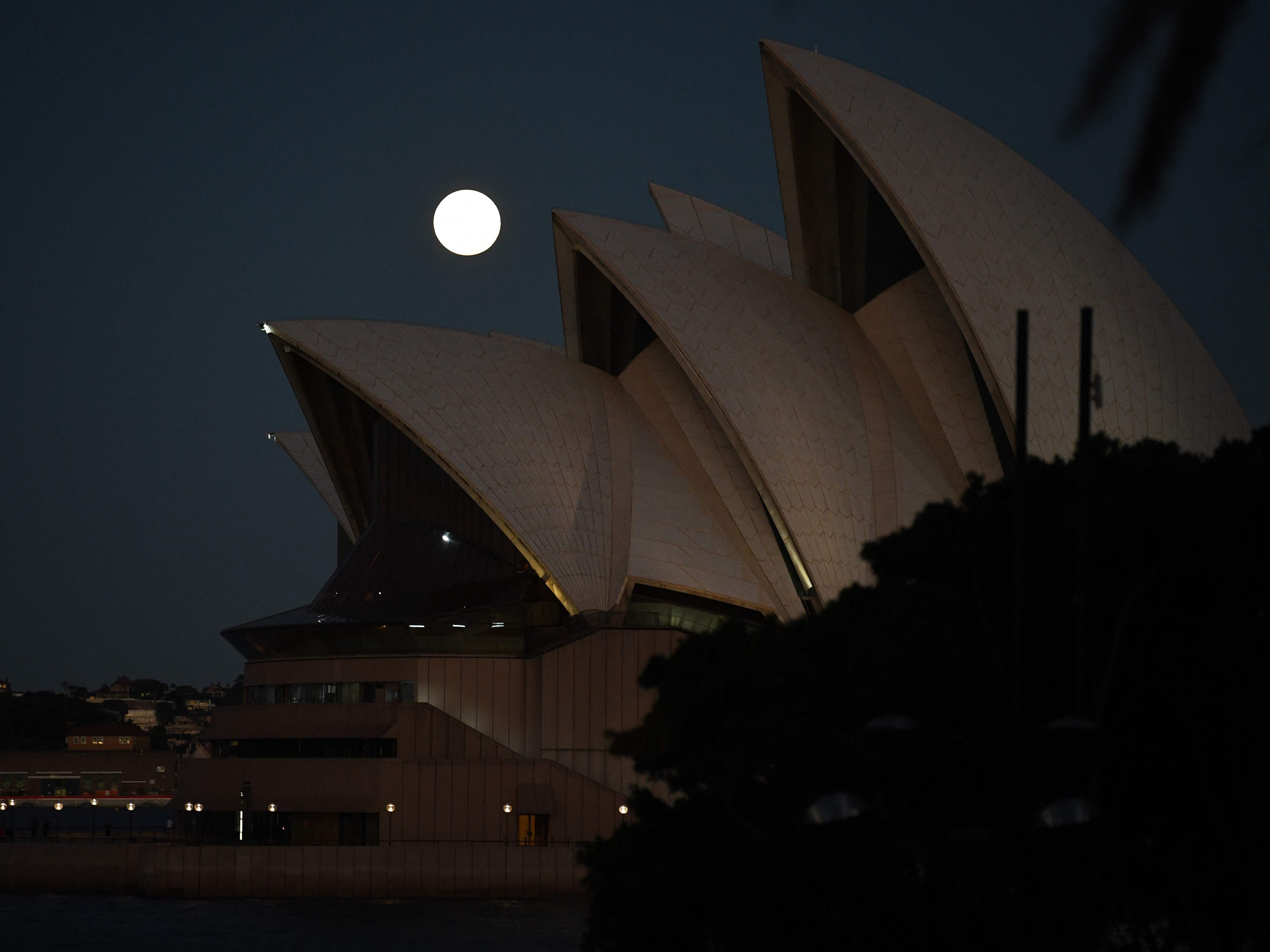 The moon rises over Sydney Opera House in Australia on Wednesday 26 May 2021