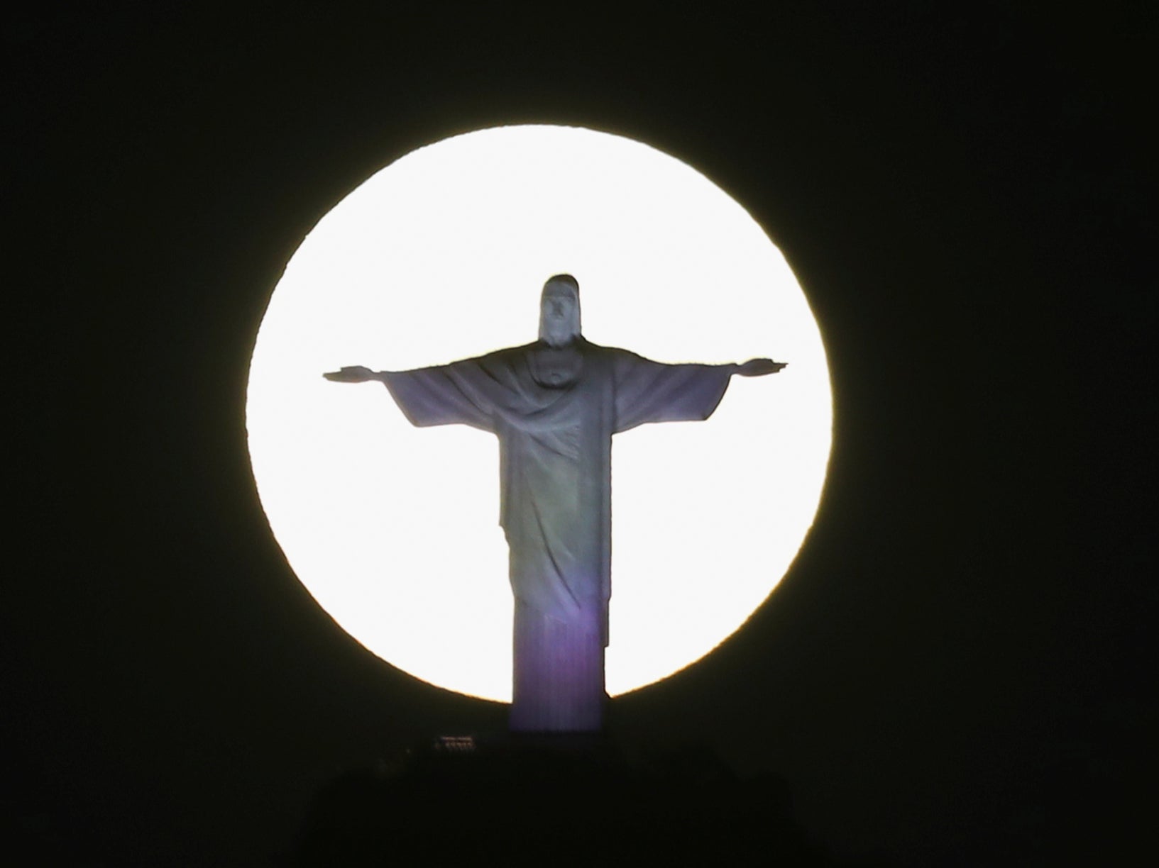 The moon shines behind Christ the Redeemer in Rio de Janeiro, Brazil, on Wednesday 26 May 2021