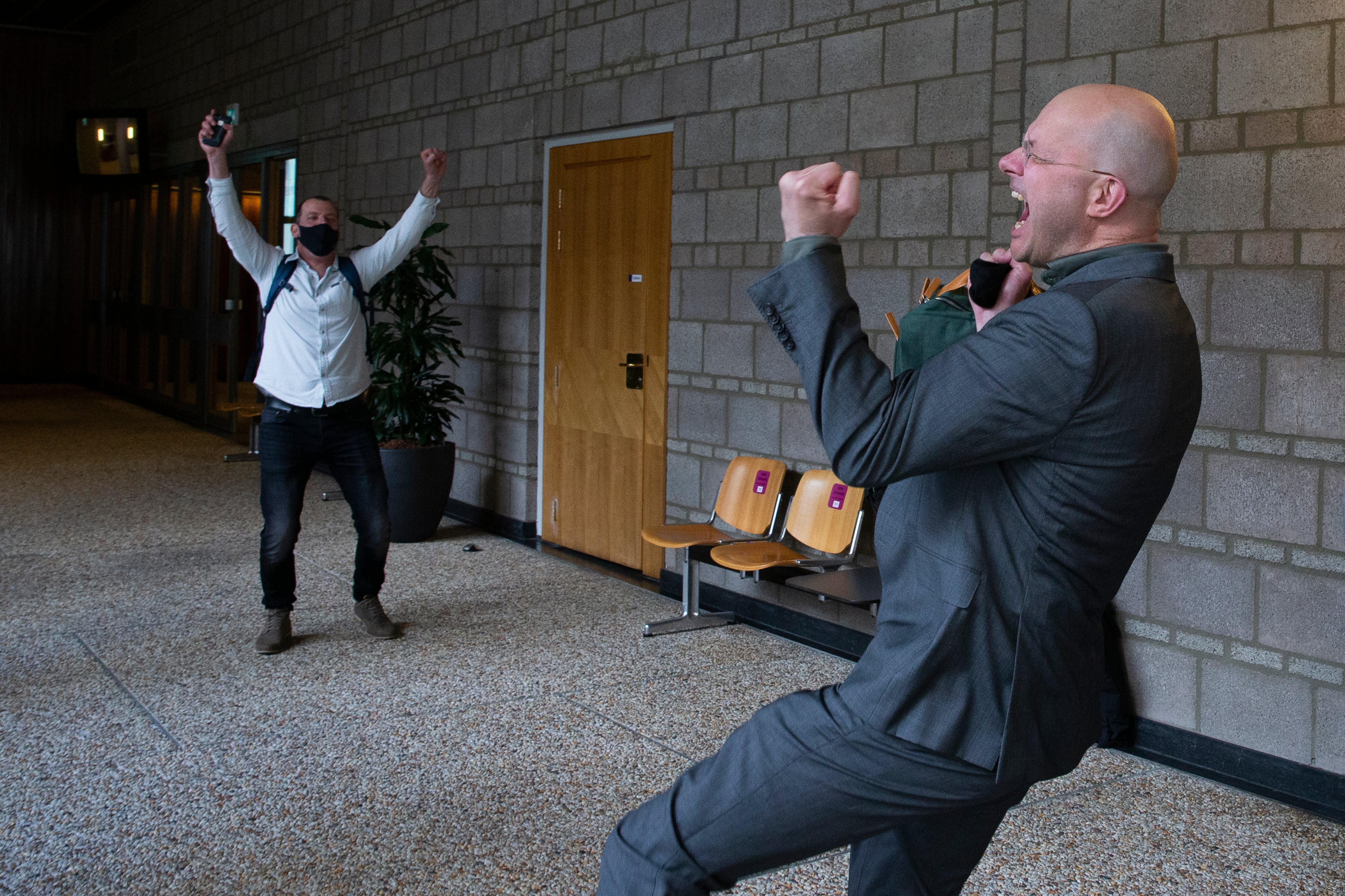 Milieudefensie director Donald Pols, right, celebrates the outcome of the verdict in the court case