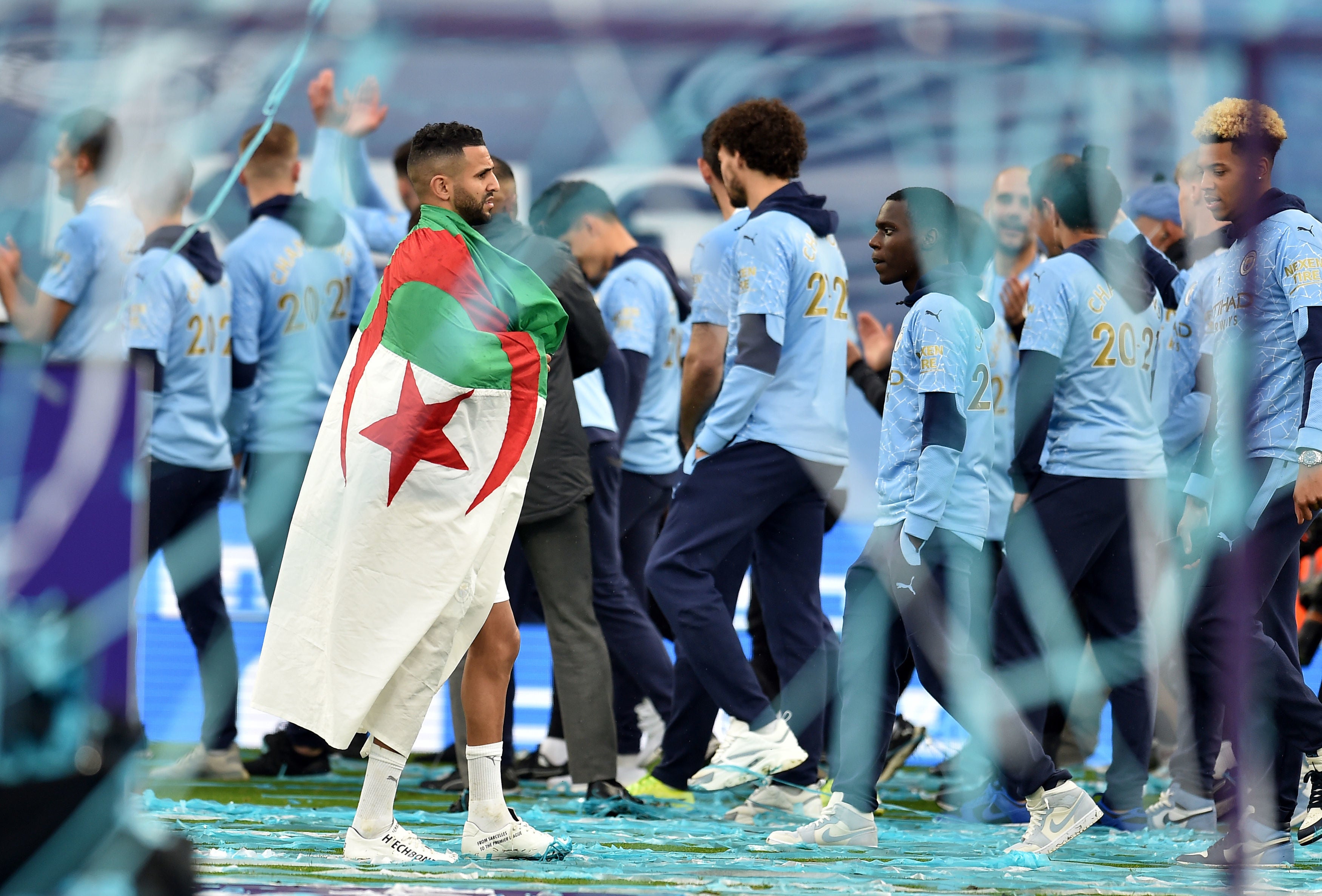 Riyad Mahrez carries the Algerian flag during title celebrations