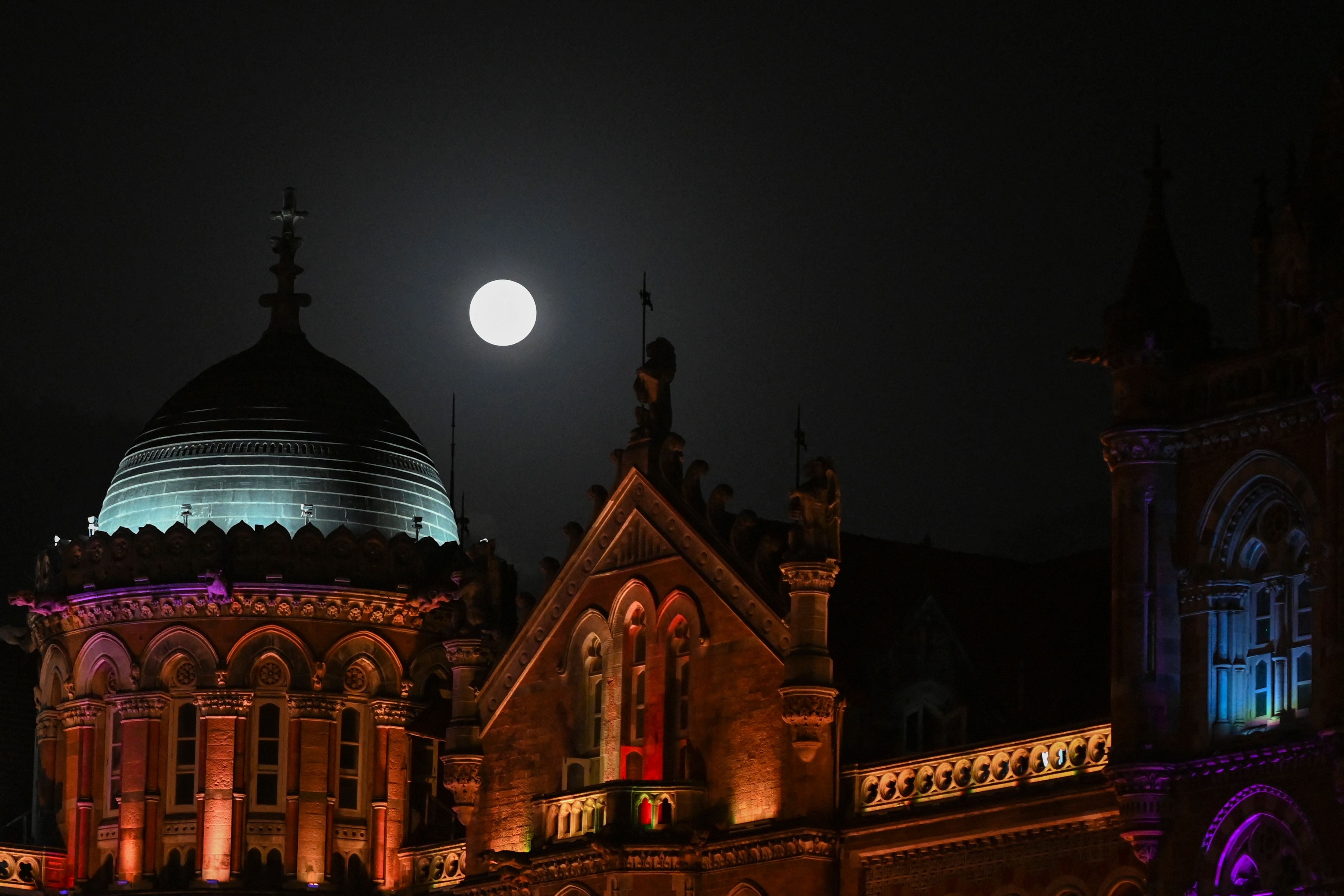 The moon pictured over the Chhatrapati Shivaji Terminus railway station building in Mumbai on 26 May 2021