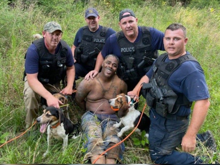Anger as armed white police officers with dogs pose with captured Black suspect