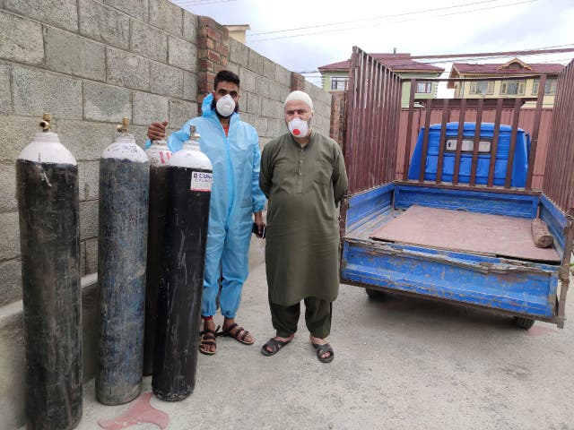 <p>Iqbal Jaan Zargar (right) with his helper Ansar Ahmad in Srinagar. The duo supply oxygen cylinders to needy families across the city for free</p>