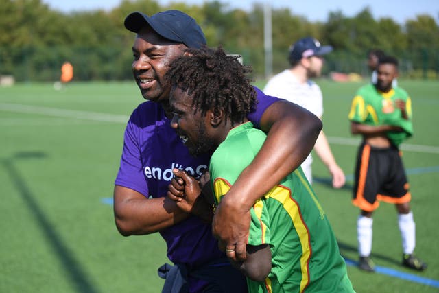 <p>The team’s founder Tomson Chalk, left, hugs Adam Hussai during a friendly match</p>