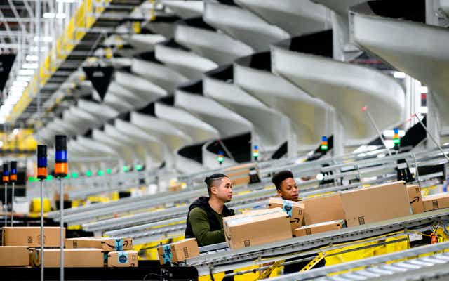 <p>Men work at a distribution station in the 855,000-square-foot Amazon fulfillment center in Staten Island, one of the five boroughs of New York City, on February 5, 2019. </p>