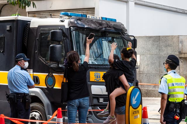 <p>Relatives wave to Correction Services Department van thought to be carrying Jimmy Lai and other prominent activists</p>