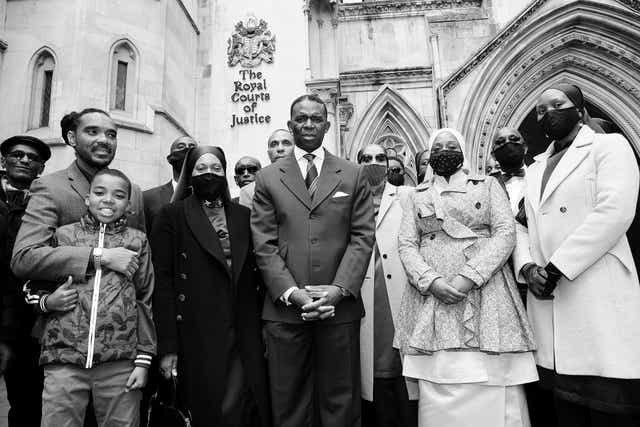 <p>The claimants stand outside the High Court following their victory</p>