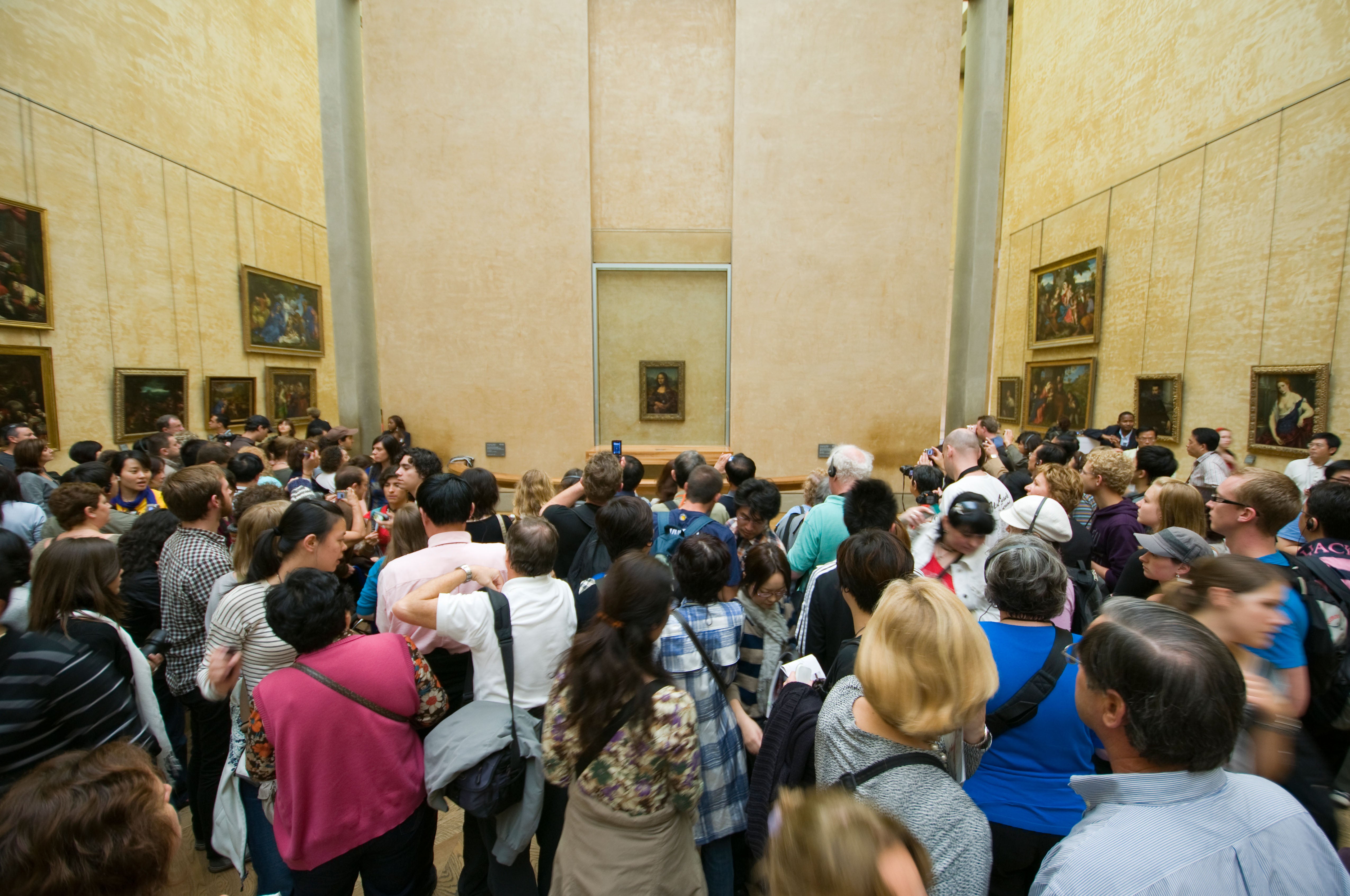 The Mona Lisa by Leonardo da Vinci on display at the Louvre in Paris. Hundreds of people gathered around to see the painting.