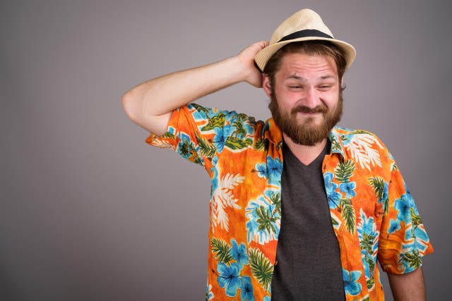 Young bearded tourist man ready for vacation against gray backgr