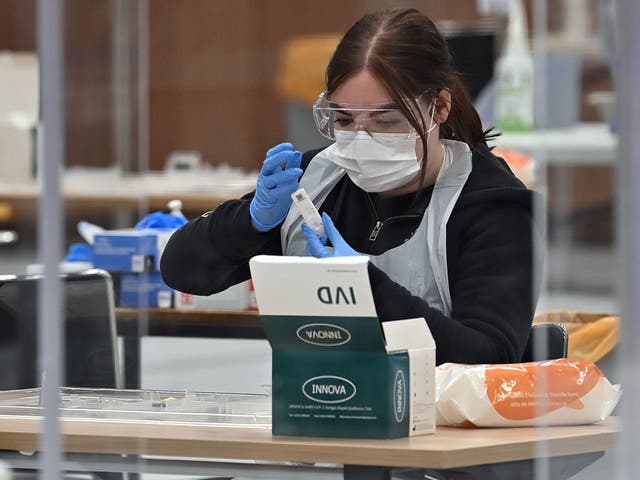 <p>A worker processes an Innova lateral flow test taken by a Hull University student in April</p>