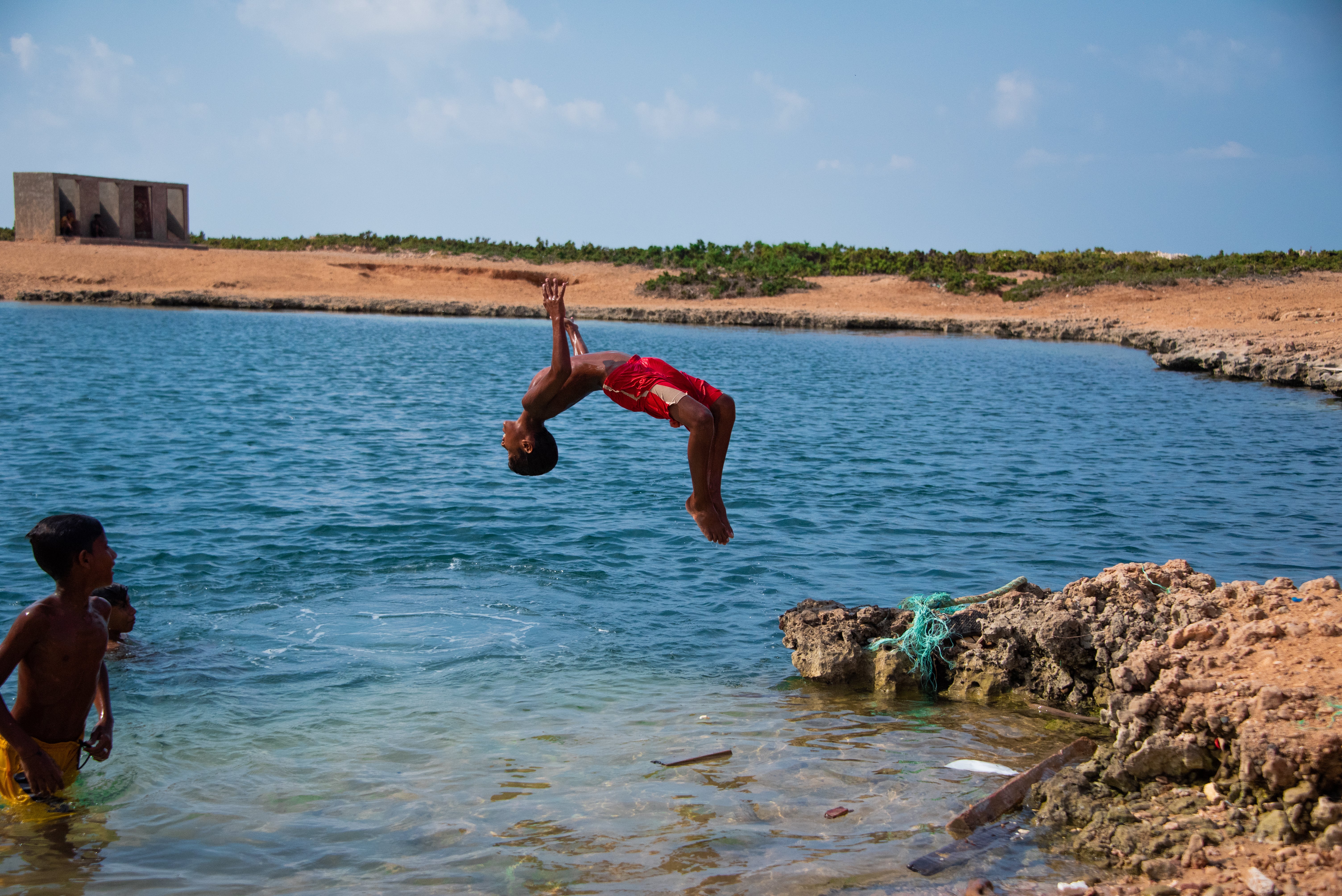 A local child dives into an impossibly deep watering hole believed to have been created by a meteorite