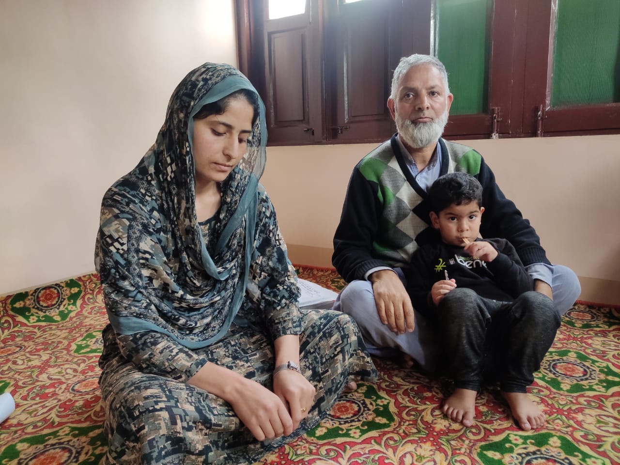 Ghulam Rasool Dar, with his daughter and grandson, at their home in Chadoora, Budgam in Kashmir