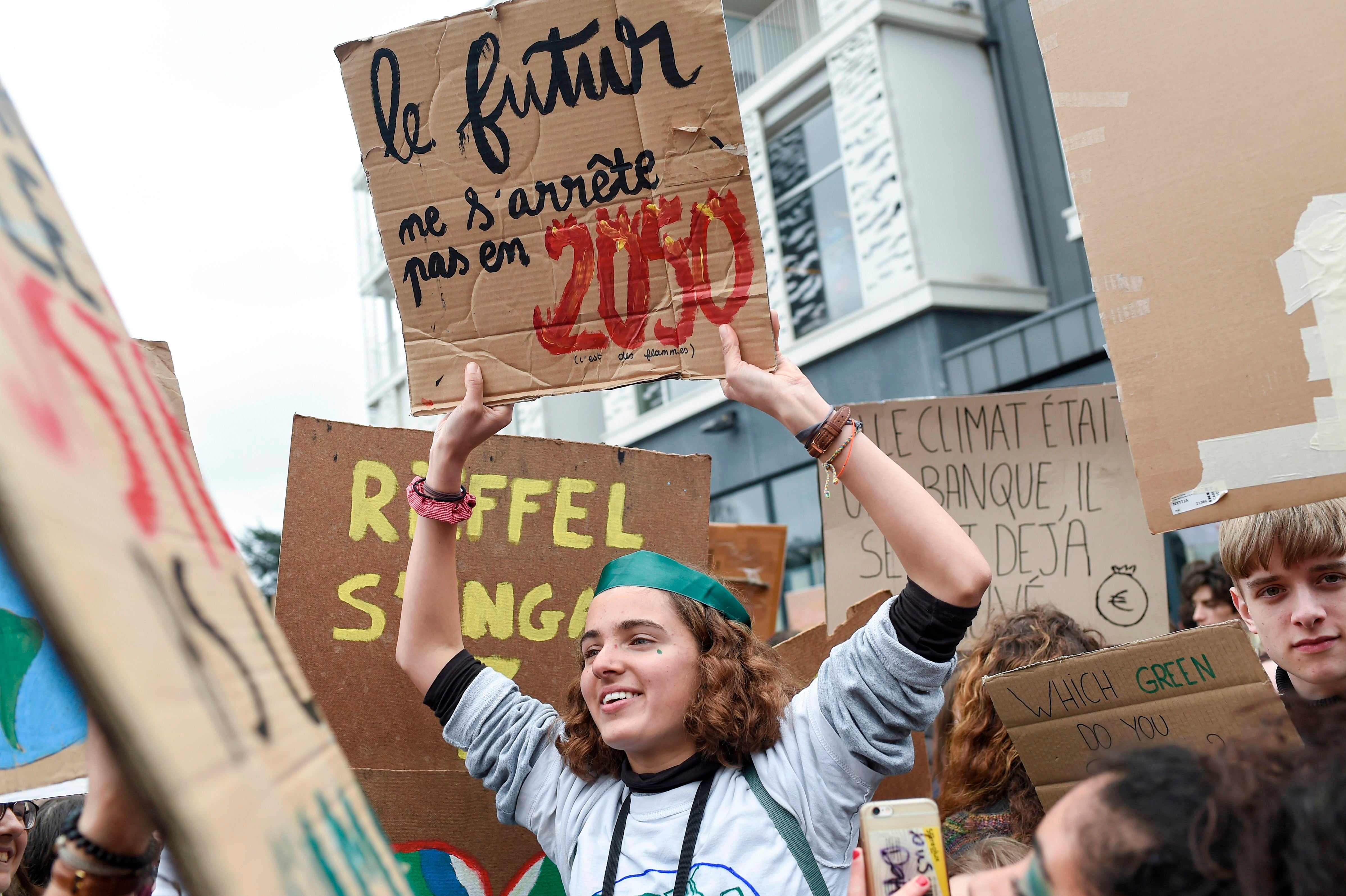 A climate protester holds a banner reading the 'future doesn't stop in 2050' during a demonstration in Nantes in 2019