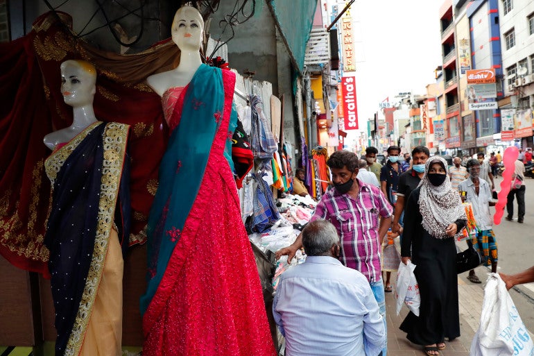 <p>A Sri Lankan Muslim woman, right in black attire, walks in a busy street of Colombo, Sri Lanka, Saturday, March 13, 2021. Sri Lanka has announced plans to ban the wearing of burqas and said it would close more than 1,000 Islamic schools known as madrassas</p>