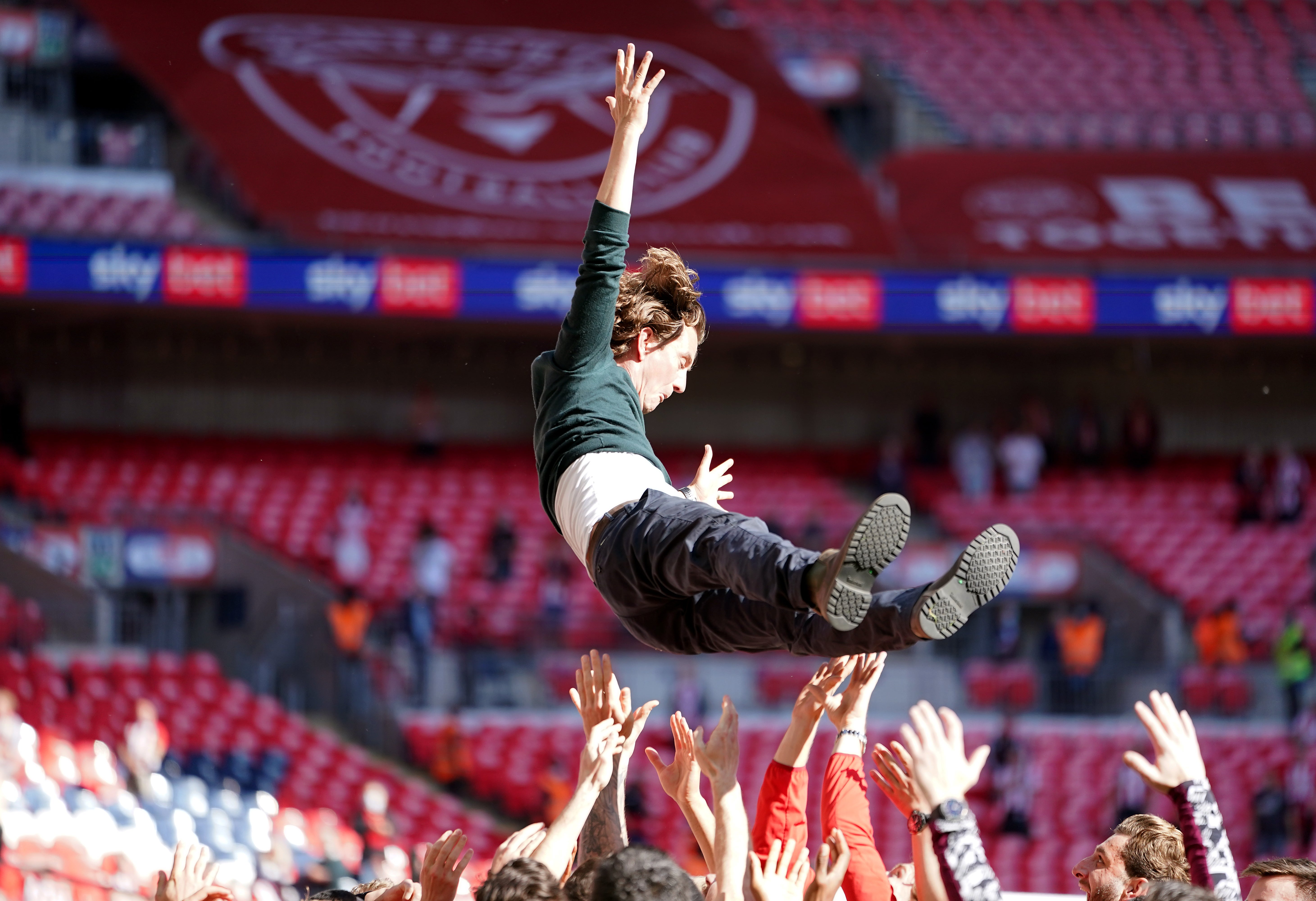 Brentford manager Thomas Frank is tossed into the air by his players as they celebrate promotion