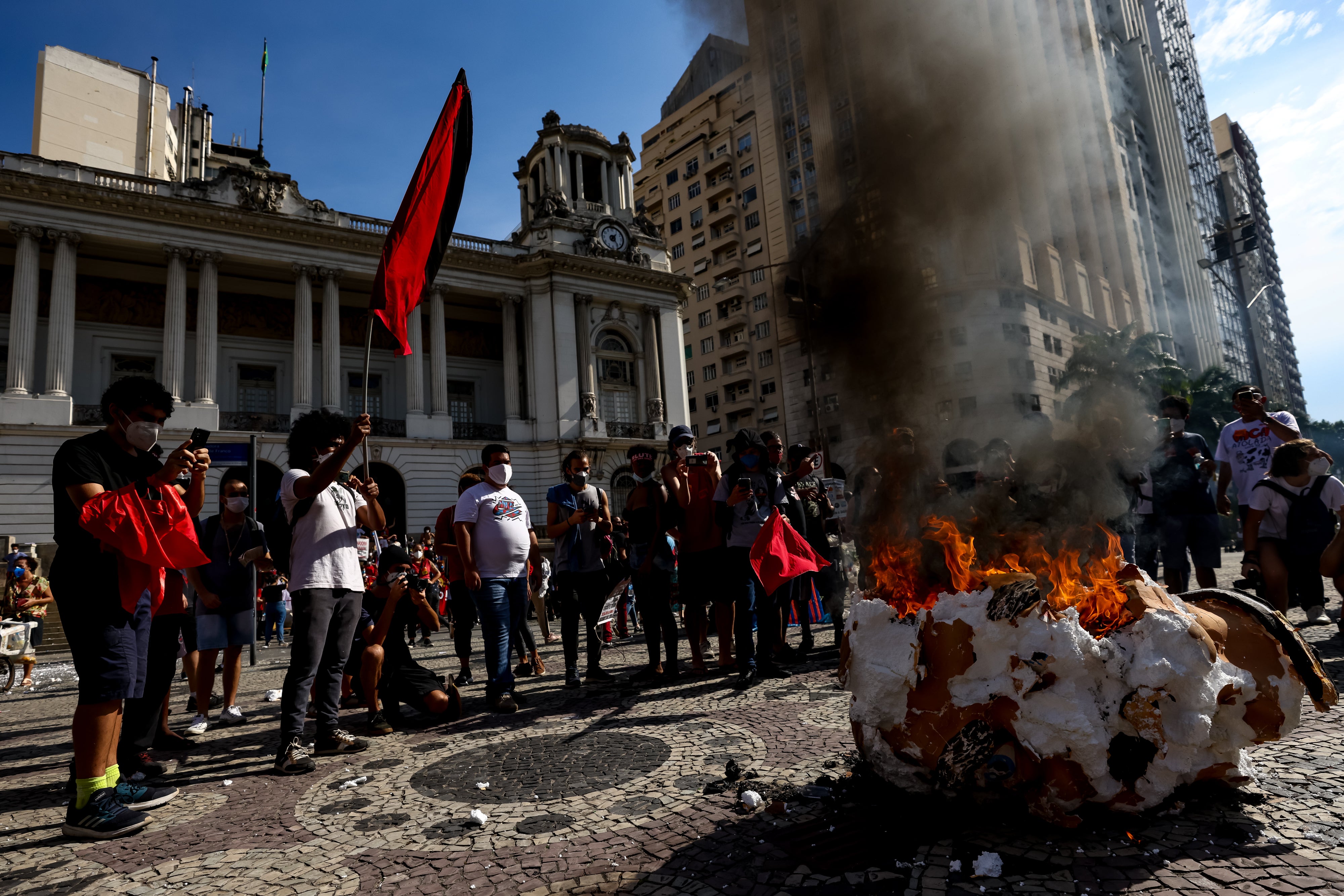 Demonstrators set fire a head prop depicting Brazilian President Jair Bolsonaro during a protest on May 29, 2021 in Rio de Janeiro, Brazil.