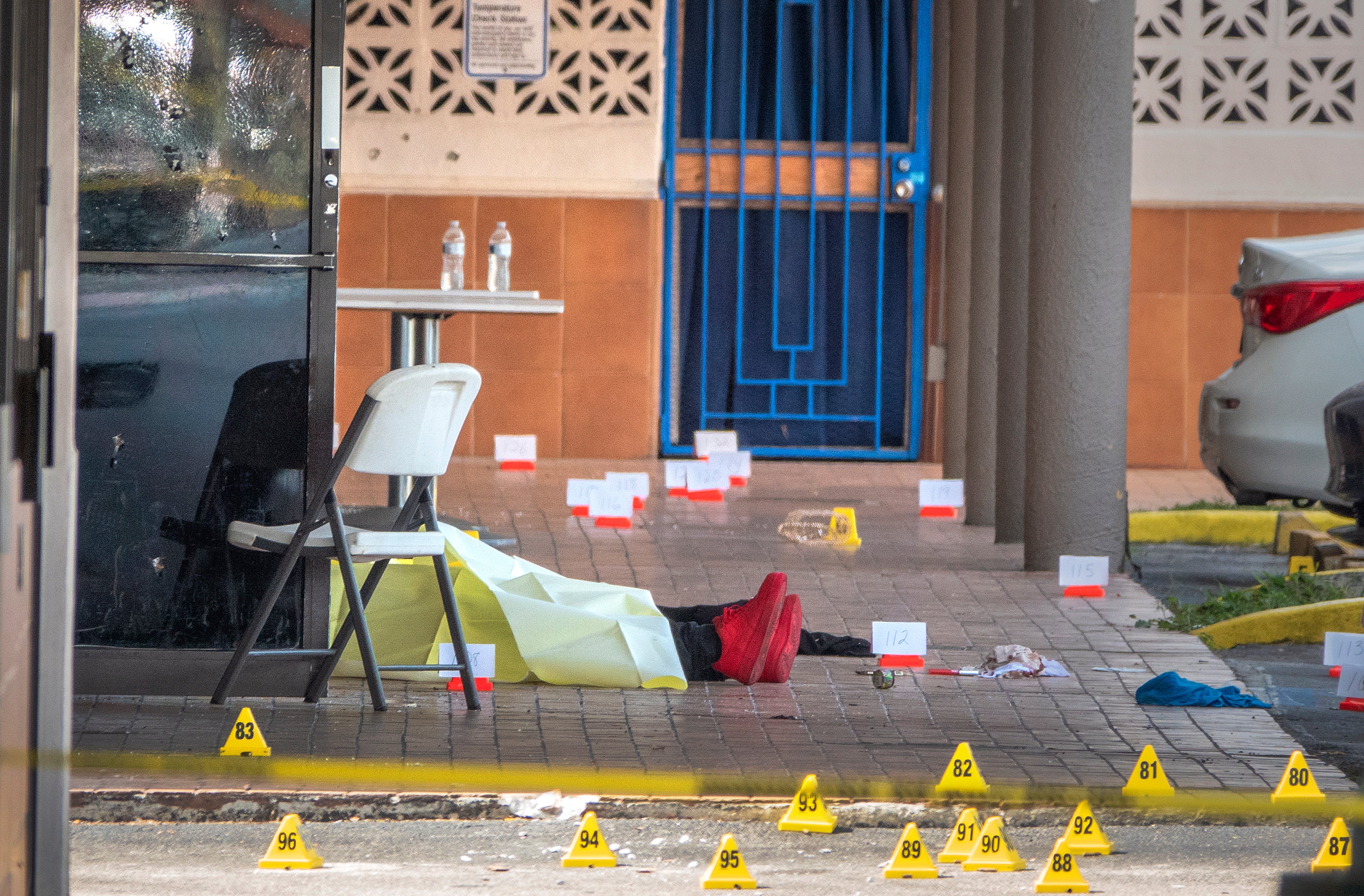 A victim's body is seen at the shooting scene at entrance of the Billiards banquet hall in Miami Gardens