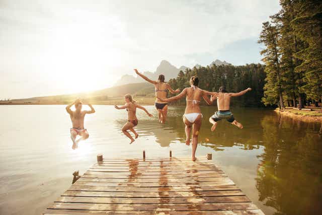Friends leaping into a lake