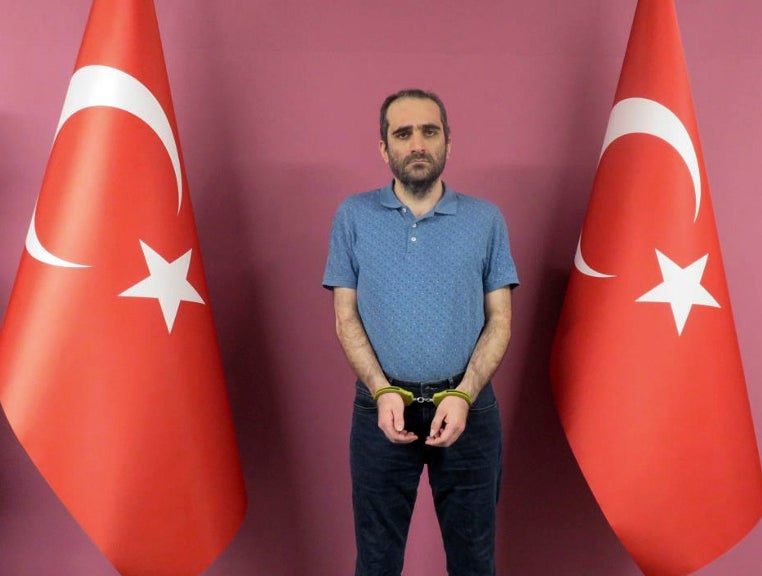 Selahaddin Gulen, a nephew of US-based Muslim cleric Fethullah Gulen, stands between Turkish flags in a photo provided by the Turkish intelligence service