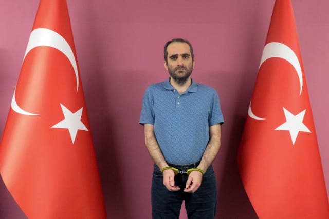<p>Selahaddin Gulen, a nephew of US-based Muslim cleric Fethullah Gulen, stands between Turkish flags in a photo provided by the Turkish intelligence service</p>