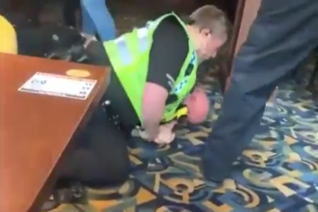<p>An officer wrestles a man to the ground in the viral video of the incident at the Blue Bell Inn in Scarborough</p>
