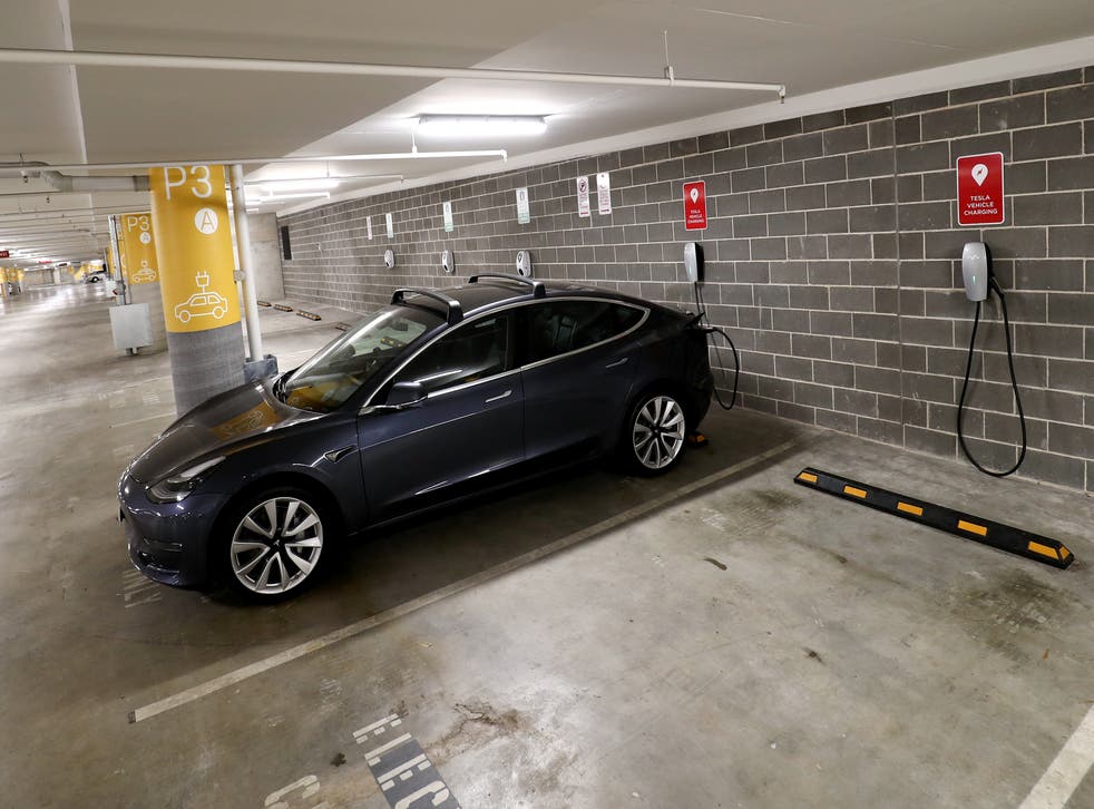 <p>A Tesla Model Y charges at a EV charge station in Lane Cove, Australia</p>