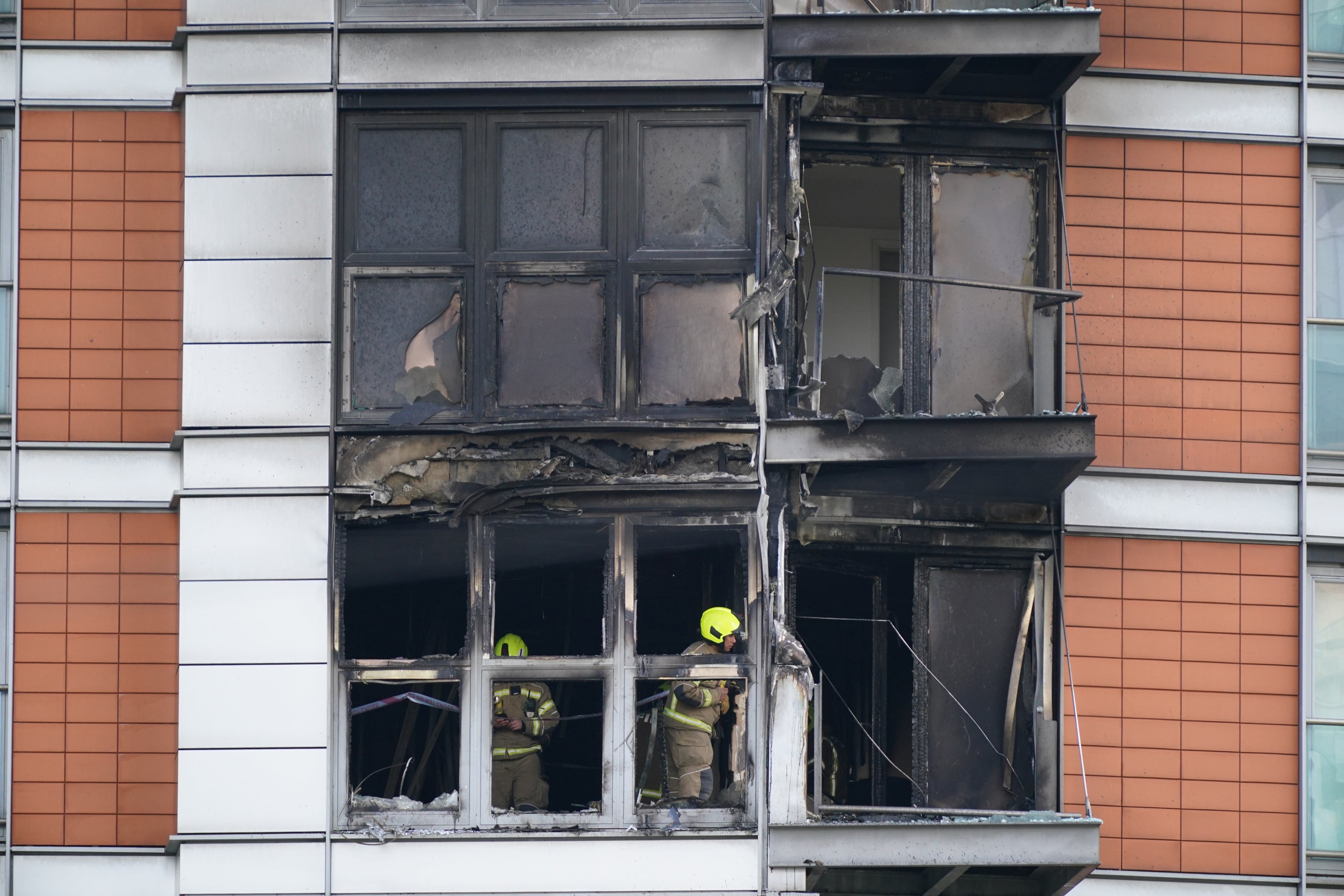 Firefighters inspect damage to a 19-storey tower block in New Providence Wharf in London