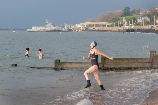 <p>Swimmers prepare for dip in the Thames estuary at Chalkwell Beach near Southend On Sea in Essex</p>