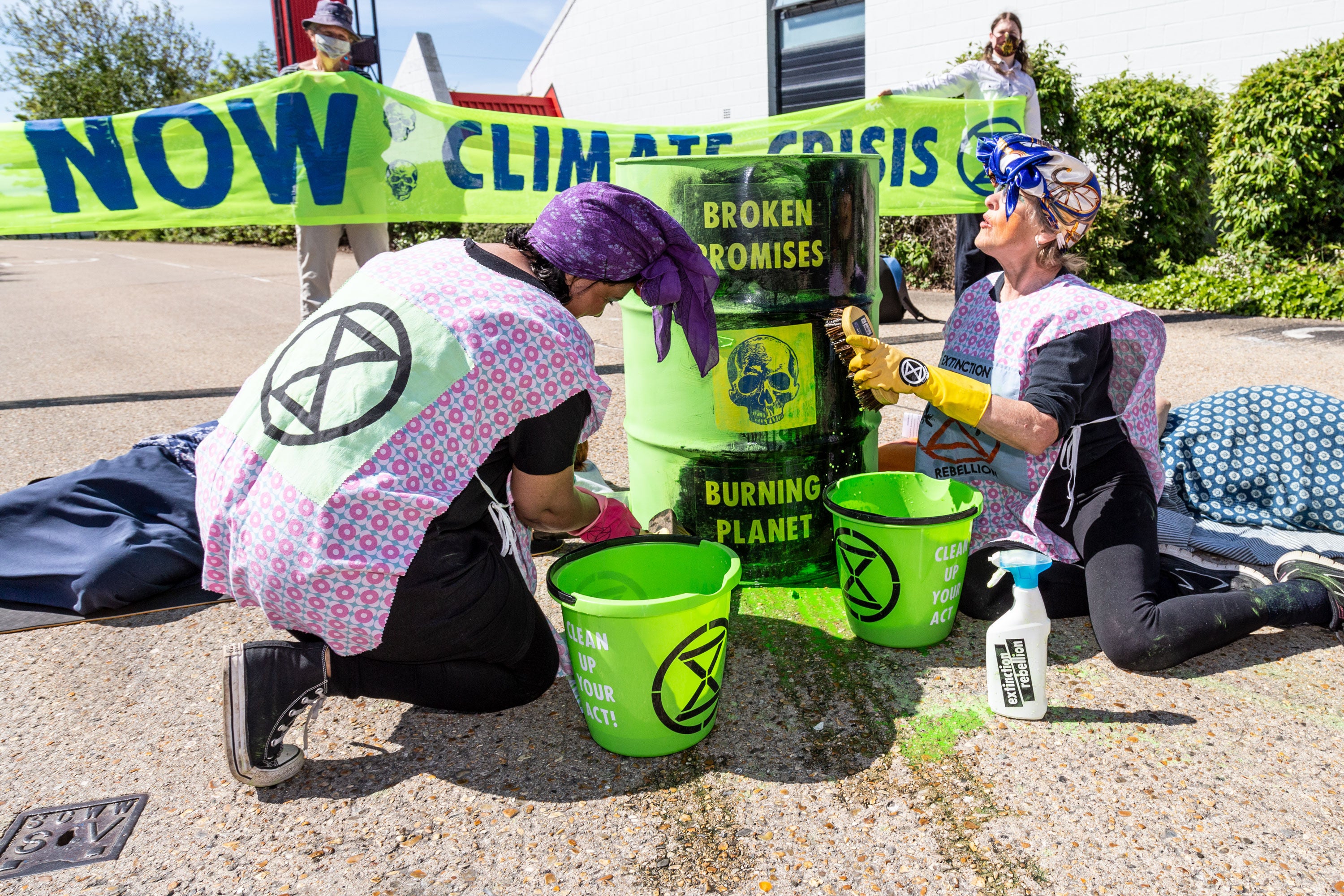 Protesters remove paint from oil drums, symbolically washing away the ‘soothing promises peddled by the UK Government and fossil fuel industry’