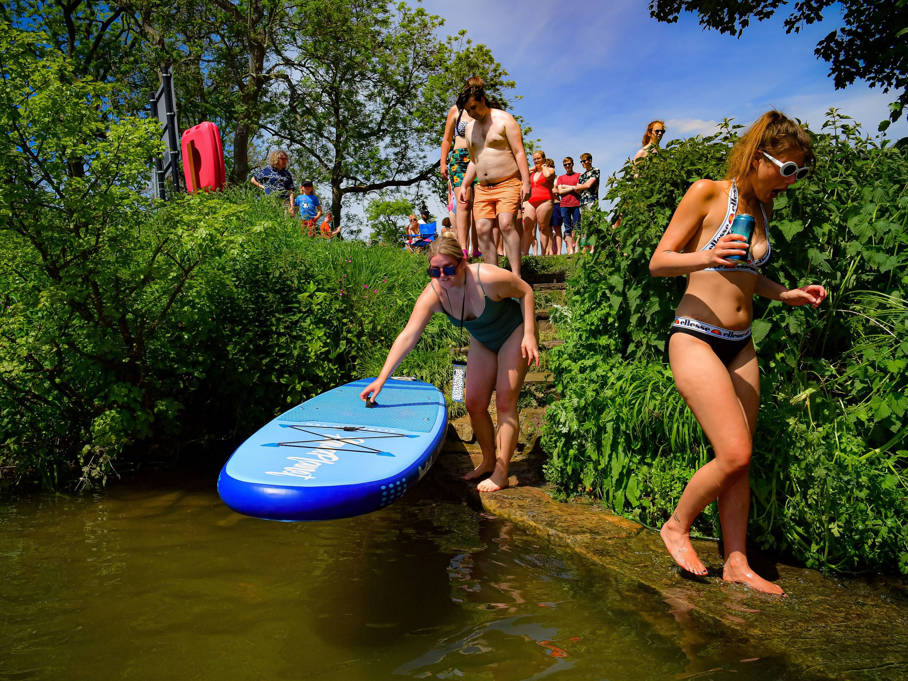 A woman gets into the water at Warleigh Weir, Bath, on the first day of meteorological summer